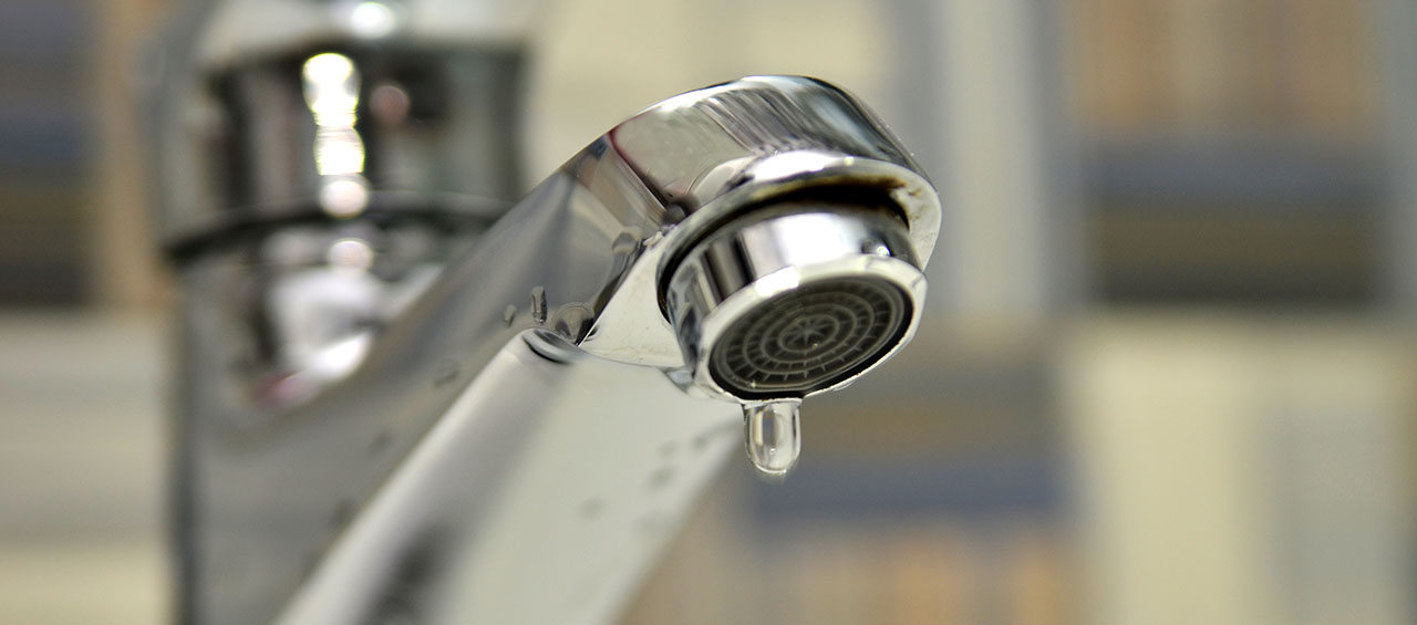 Bathroom tap leaking water drops. Saving water concept