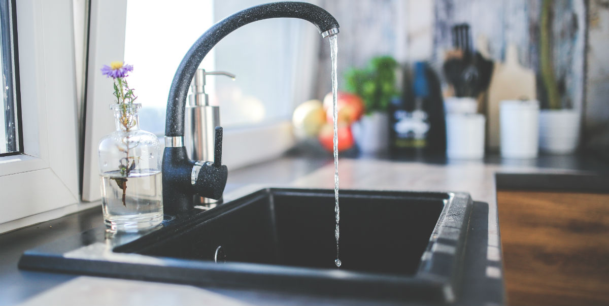 Black kitchen faucet with water tap on