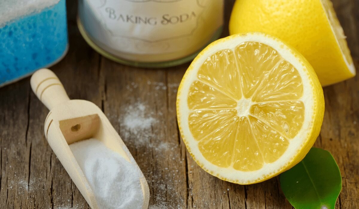 a scoop of baking soda beside a lemon cut in half